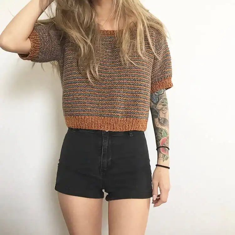A stylish Callie Crop Top, knitted in a modern design, paired with jeans or shorts, suitable for warm weather.