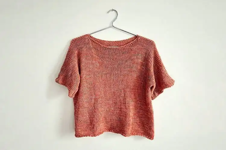A model wearing a cozy, oversized knitted Slouchy T-Shirt crop top in a neutral shade, emphasizing its relaxed fit and comfortable style.
