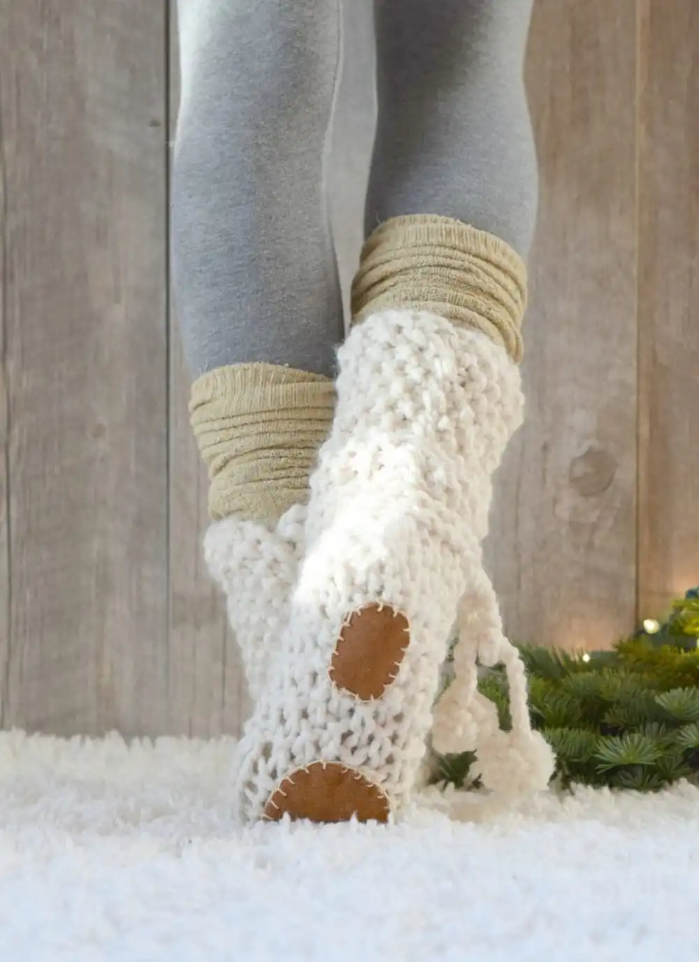 Crochet slippers with a visible, sturdy leather sole attached for durability.