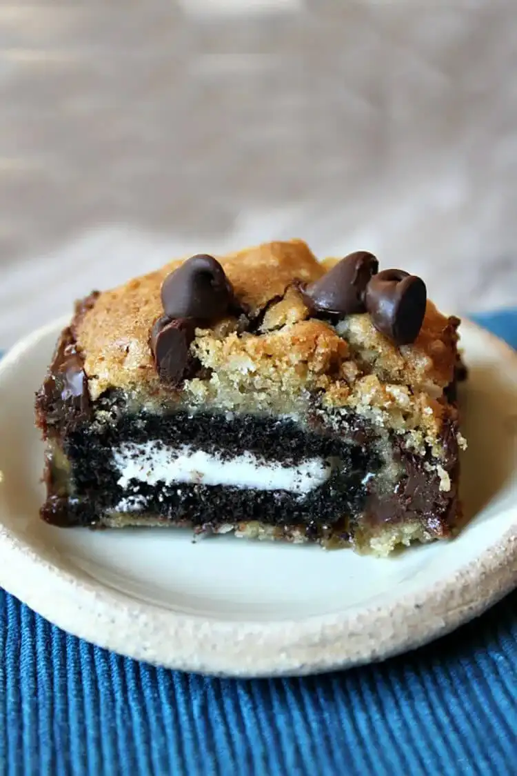 Cross-section of an Oreo Stuffed Cookie Bar revealing layers of chocolate chip cookie, Oreo, and caramel