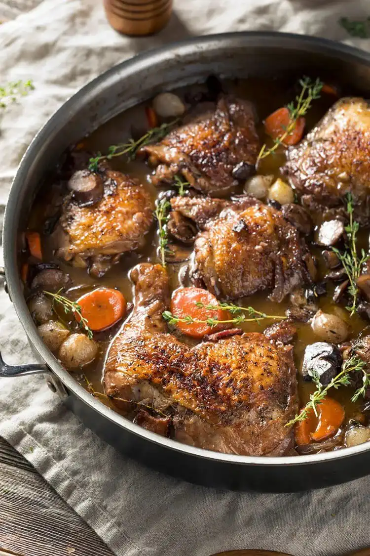 Pot-roast pheasant with chorizo, butter beans, and parsley in a skillet, ready to serve.