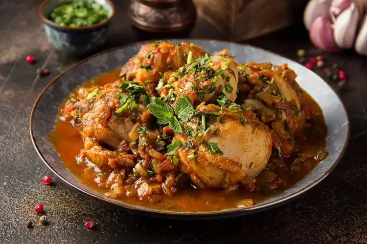A rustic bowl of Pheasant Normandy Stew with apple slices and a rich sauce.