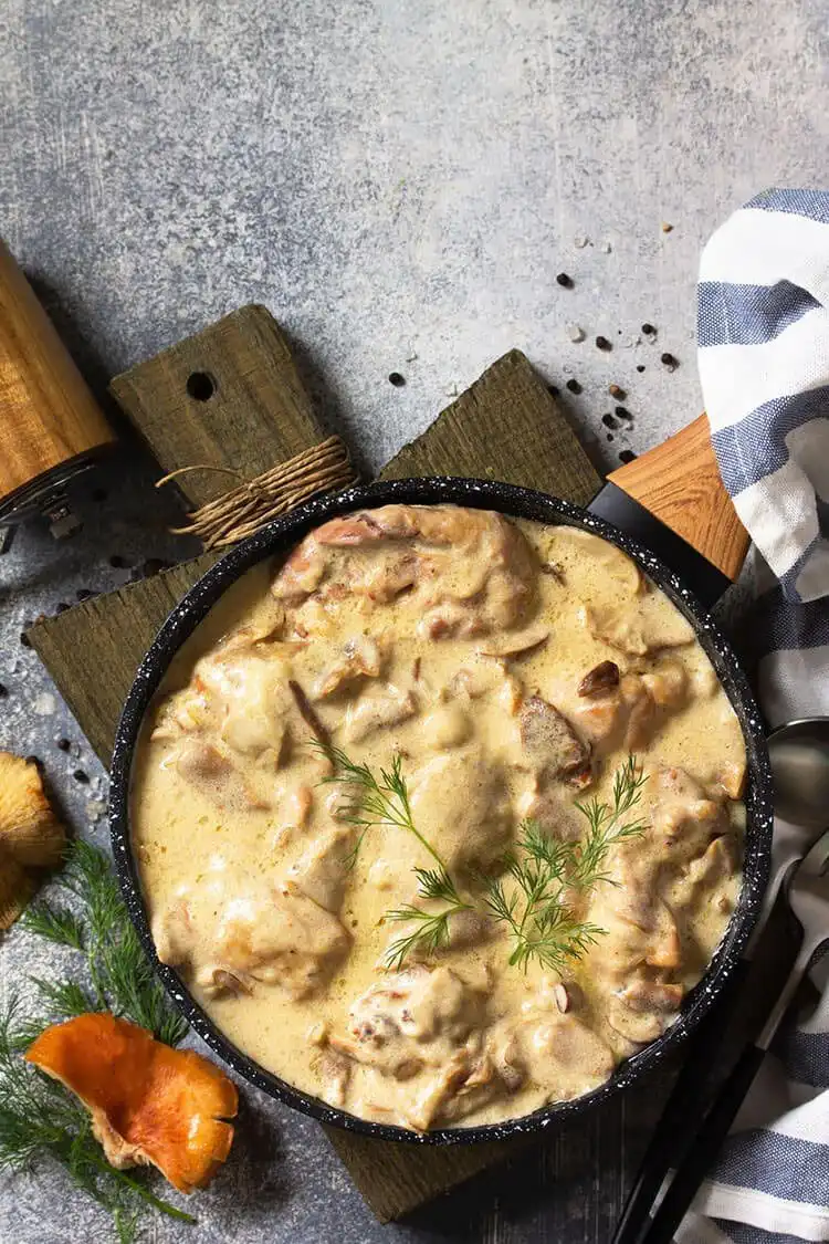 Pheasant pieces in a creamy mustard sauce, garnished with fresh herbs.