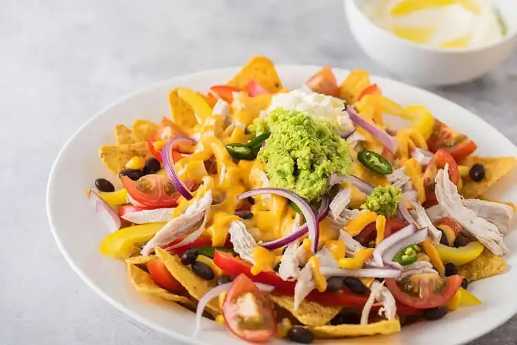 Slow cooker pheasant nachos loaded with cheese, jalapeños, and fresh toppings.