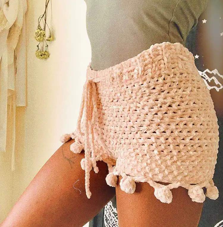 14 Gorgeous Crochet Shorts Patterns for Women 8 Playful high-waisted crochet shorts adorned with small pom-poms along the edges.
