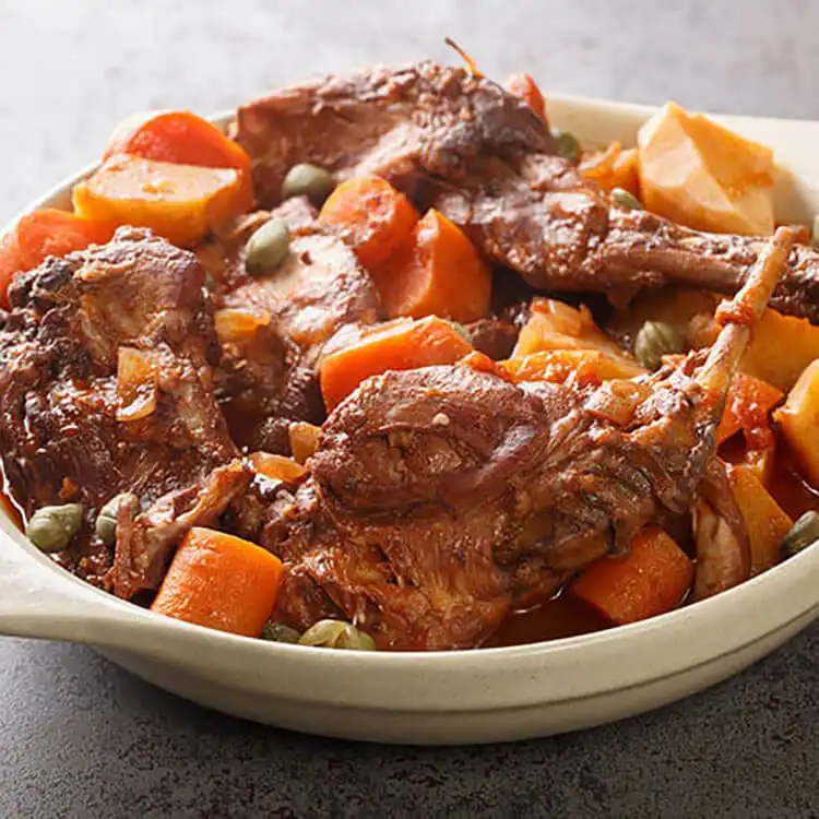 14 Rabbit Recipes that will Make your Mouth Water 1 A rustic arrangement of various cooked rabbit dishes, showcasing 14 rabbit recipes that will make your mouth water.