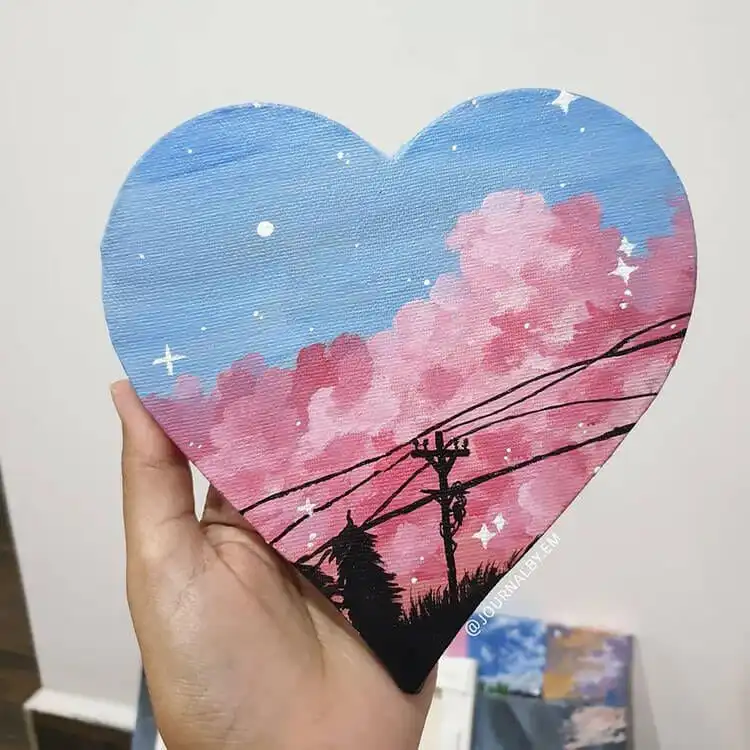 Sky painting on a heart-shaped canvas, featuring blended sunset colors.