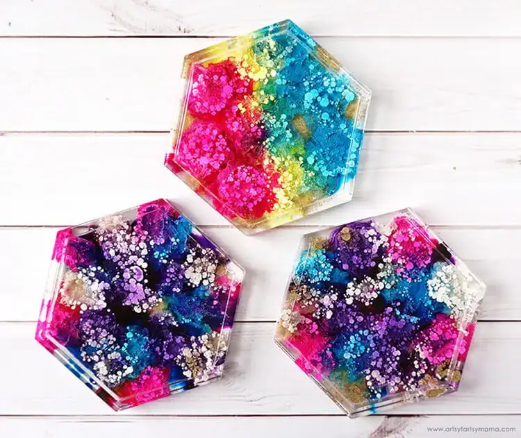 A set of unique resin petri dish coasters with vibrant alcohol ink blooms and cellular patterns.
