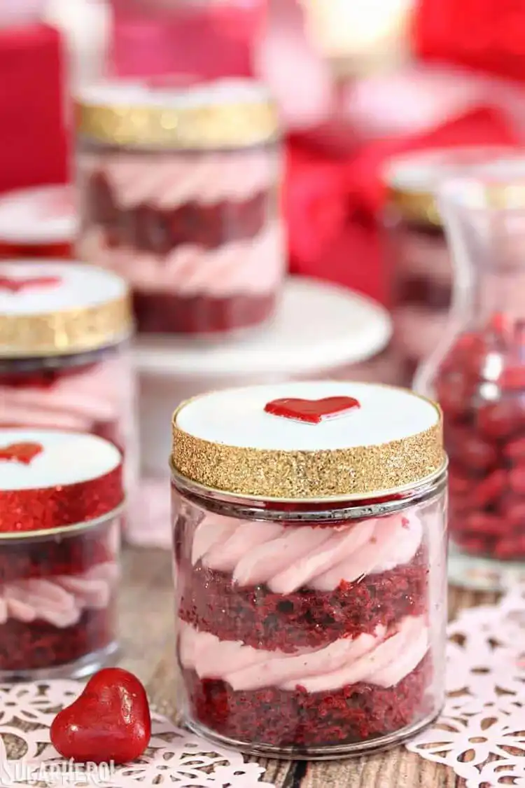 Elegant Red Velvet Cake in a Jar with layers of red velvet cake and strawberry cream cheese frosting, topped with chocolate shavings.