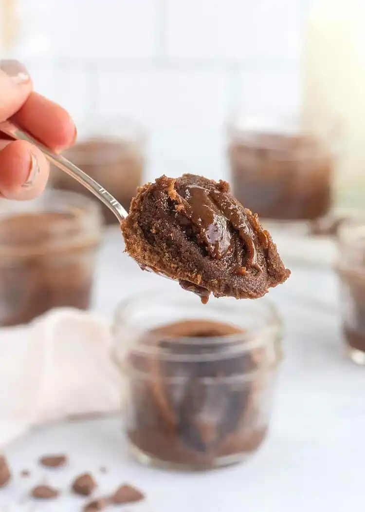 Gooey Molten Chocolate Cakes baked in small jars, ready to be served warm with ice cream.
