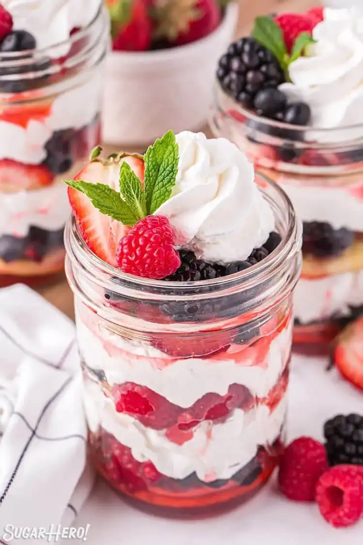 Berry Shortcake in a Jar filled with mixed raspberries, blackberries, crescent dough, and whipped cream.