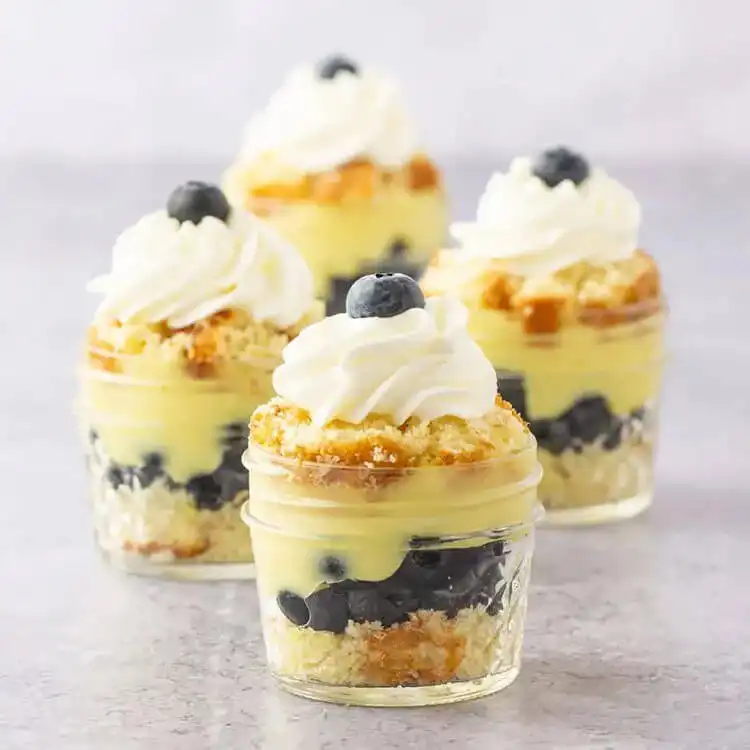 Blueberry Lemon Pudding Cake In A Jar with refreshing layers of lemon cake, fresh blueberries, and whipped cream.