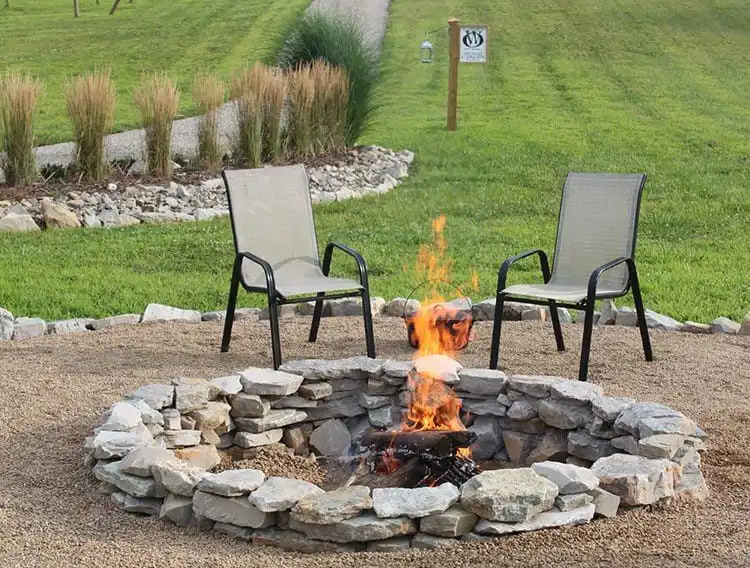 Elegant $117 DIY Fire Pit Project constructed from sleek grey concrete blocks in a modern backyard setting, surrounded by pea gravel.
