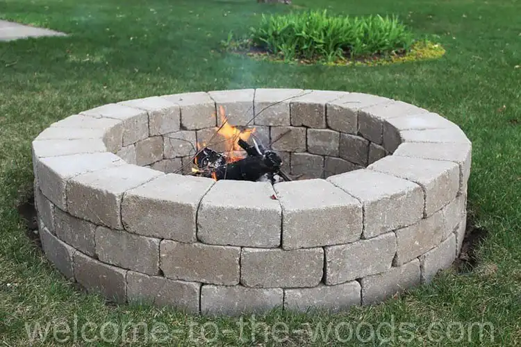 Economical DIY Round Fire Pit built from stacked rough-hewn stone blocks, showcasing an attractive and very affordable outdoor feature for $63.