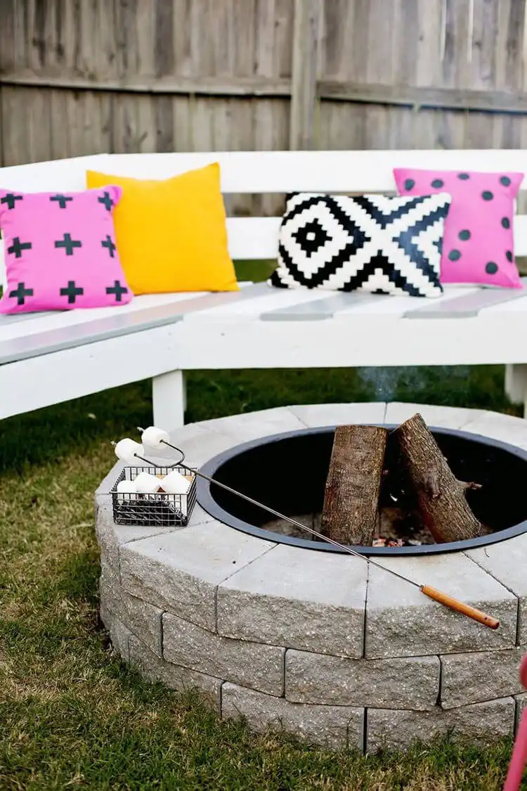 Quick Make Your Own Fire Pit in 4 Easy Steps, showing a simple circular fire pit made from stacked grey landscape blocks on a gravel patio.