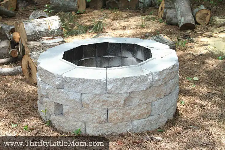 Accessible Easy DIY Firepit for Backyard Fun, a simple stone-look concrete block fire pit surrounded by natural grass, ideal for family use.