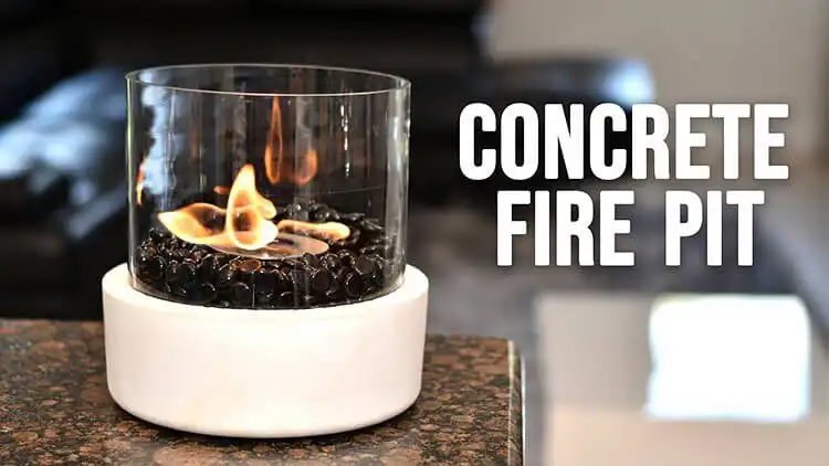 Modern Concrete Tabletop Fire Bowl, a sleek rectangular design with river rocks and a small flame, perfect for patio centerpieces.