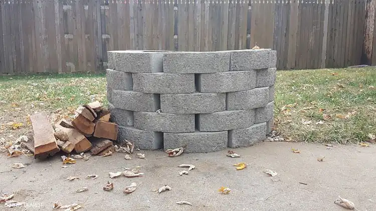 Simple and The Easiest Way to Build Your Own Fire Pit, made from stacked large grey landscape bricks, demonstrating quick, mortarless construction.
