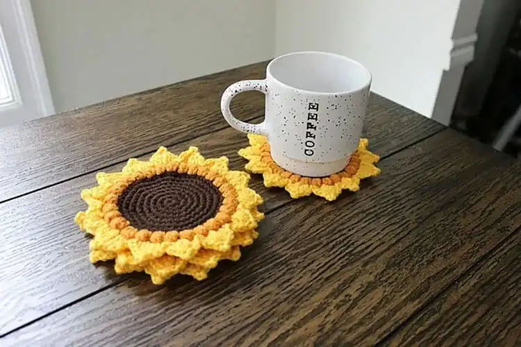 Vibrant crochet sunflower cup coasters on a table