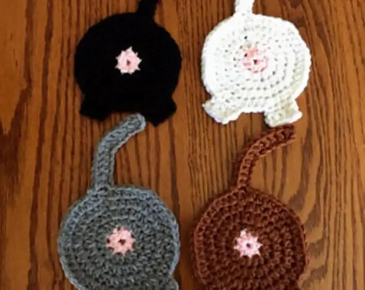 Humorous crochet cat butt coaster with distinct tail detail