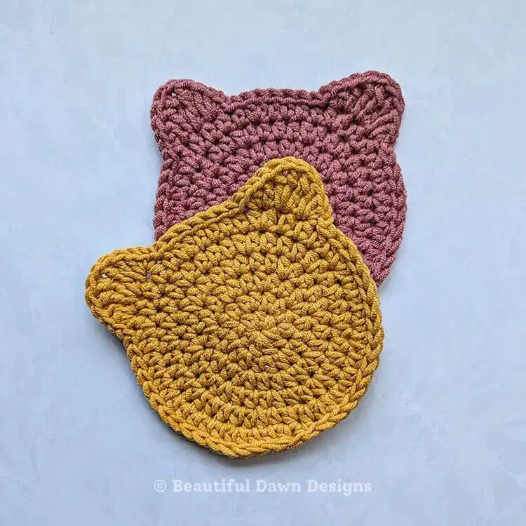 Adorable grey crochet cat face coaster with embroidered features