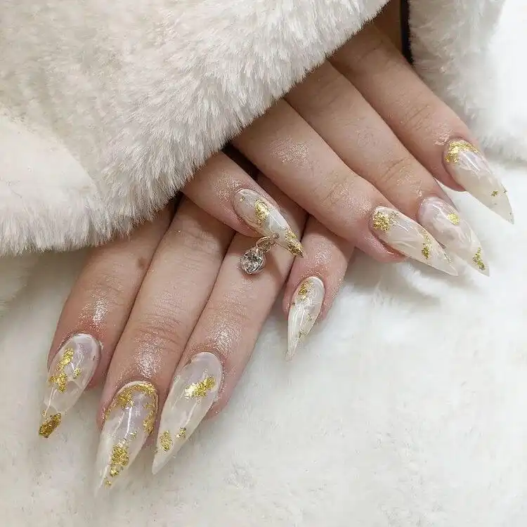 Long white nails with a half-white design and striking gold accents.