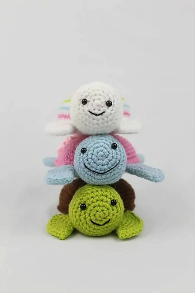 A tiny amigurumi crochet turtle, barely an inch or two tall, perfect for using up small yarn amounts.