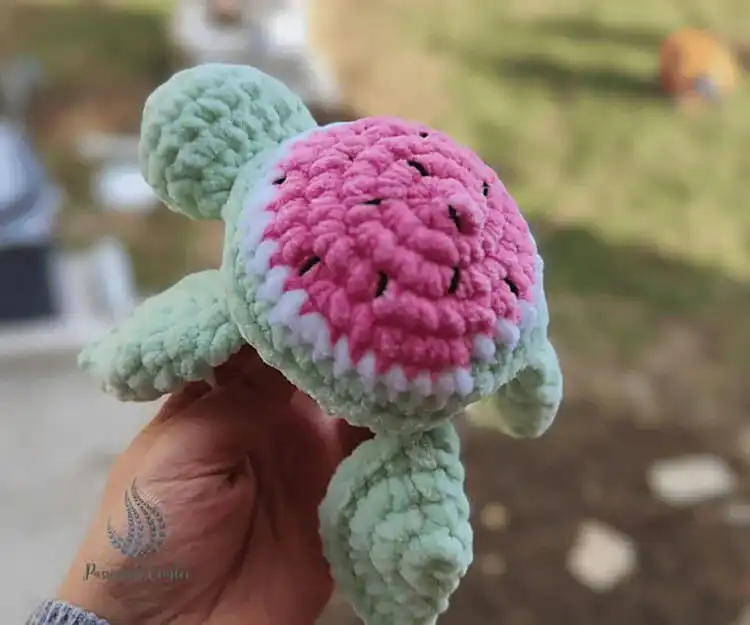 A mini watermelon crochet turtle, featuring green and pink colors resembling a refreshing slice of watermelon.