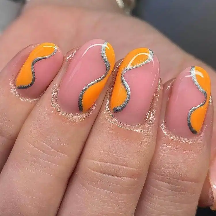 18 Simple Orange Nail Designs - Heart Nails 12 Orange nails adorned with elegant silver swirl designs, creating a sophisticated and artistic look.