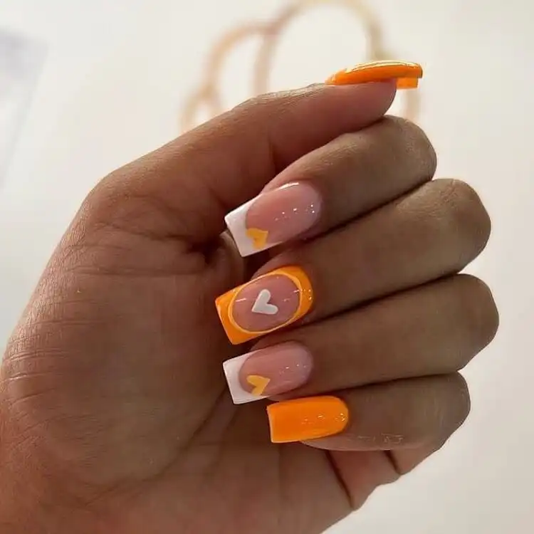 18 Simple Orange Nail Designs - Heart Nails 17 Creative orange and white nails with French tips, intricate patterns, and tiny heart accents.