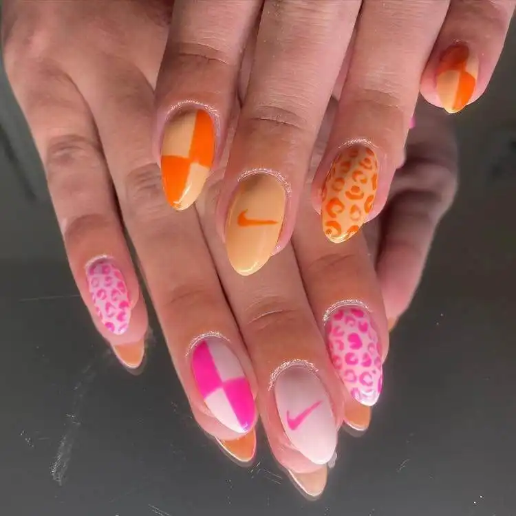 18 Simple Orange Nail Designs - Heart Nails 18 Nail design incorporating the Nike logo with other patterns, featuring an orange color palette.