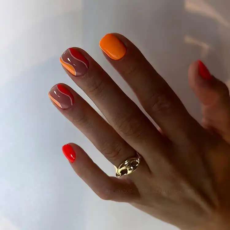 18 Simple Orange Nail Designs - Heart Nails 20 Dynamic wavy nail art in two different shades of orange, creating movement and visual interest.