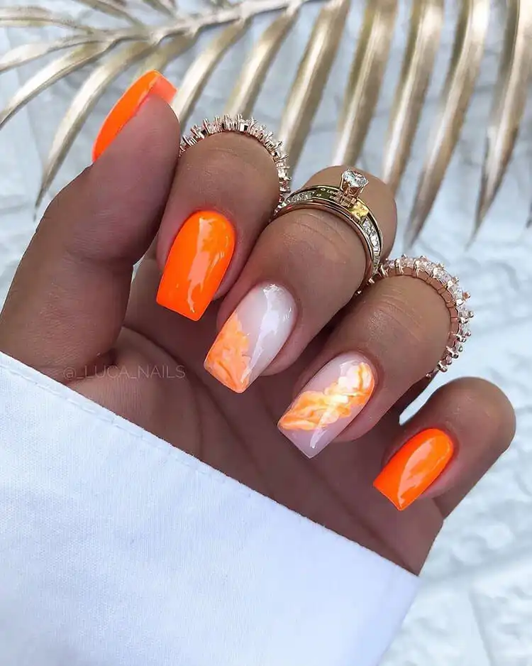 18 Simple Orange Nail Designs - Heart Nails 21 Modern manicure combining solid orange nails with a few accent nails featuring an orange marble effect.