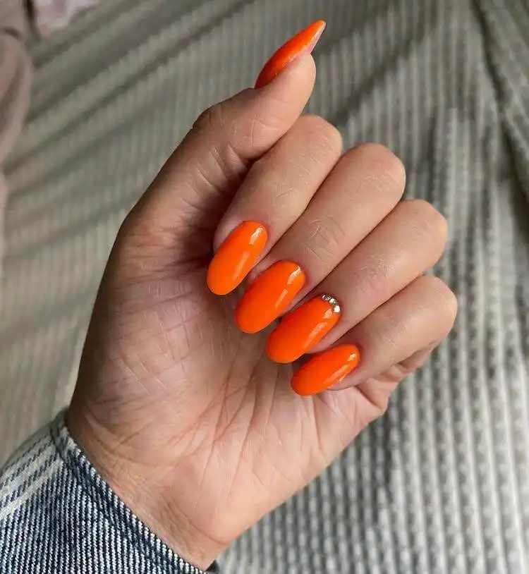 18 Simple Orange Nail Designs - Heart Nails 5 Vibrant orange nails embellished with sparkling rhinestones for an elegant touch, part of 18 Simple Orange Nail Designs.
