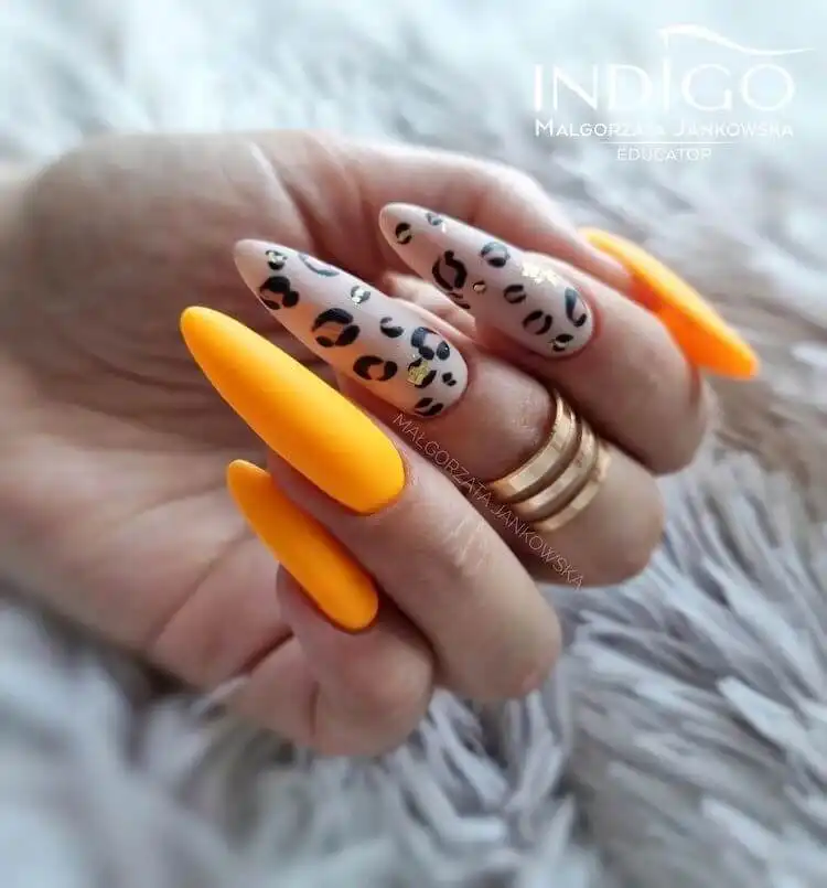 18 Simple Orange Nail Designs - Heart Nails 6 Chic orange acrylic nails featuring a cheetah print accent nail with gold foil details, a stylish animal print orange nail design.