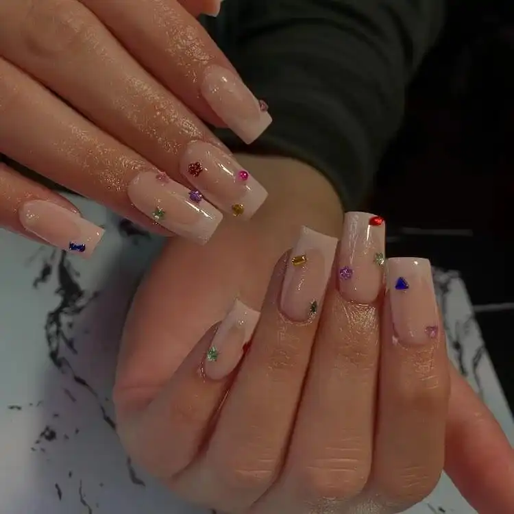 Tapered square nails adorned with cute, colorful rhinestones in various shapes.