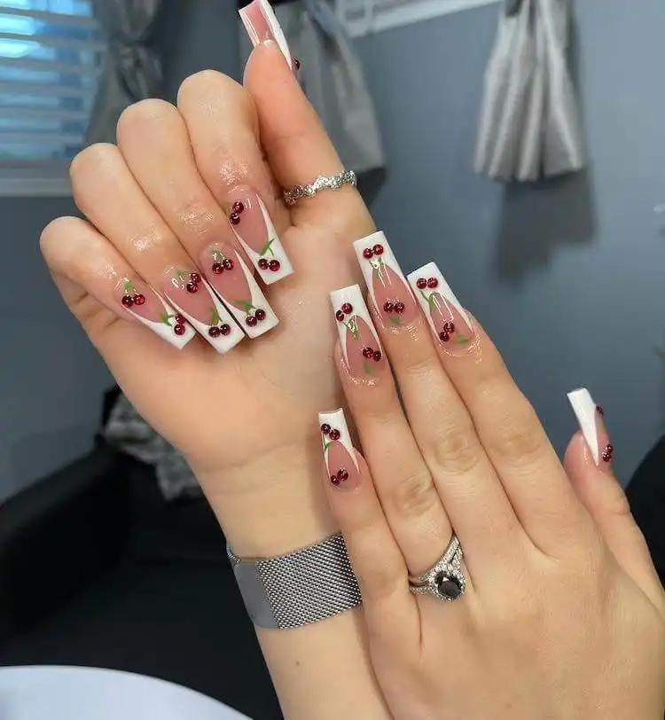 Tapered square nails decorated with stunning red cherry designs.