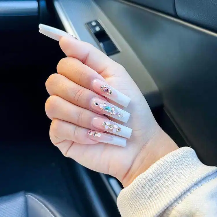 Long tapered square nails featuring cute bears, abundant rhinestones, and glitter.