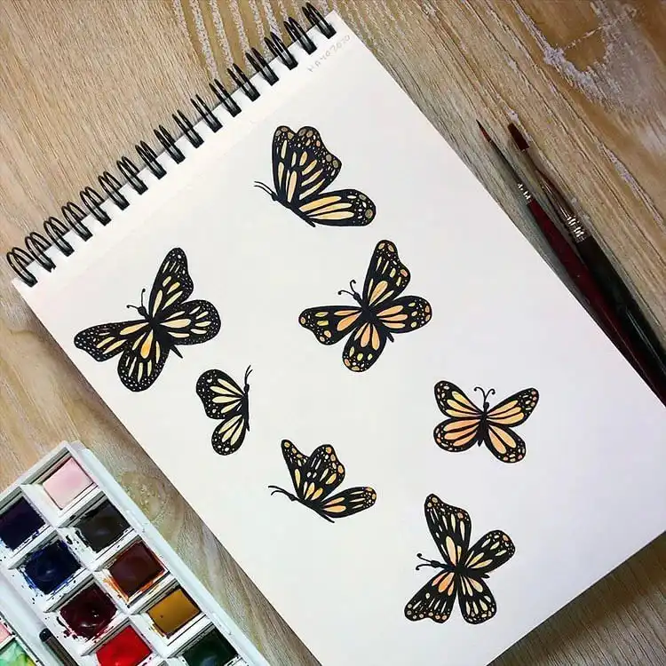 Charming watercolor scene of butterflies gracefully fluttering over a bouquet of flowers.