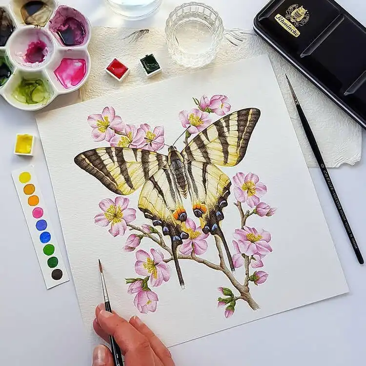 Detailed watercolor painting of a butterfly with a soft floral tree background.