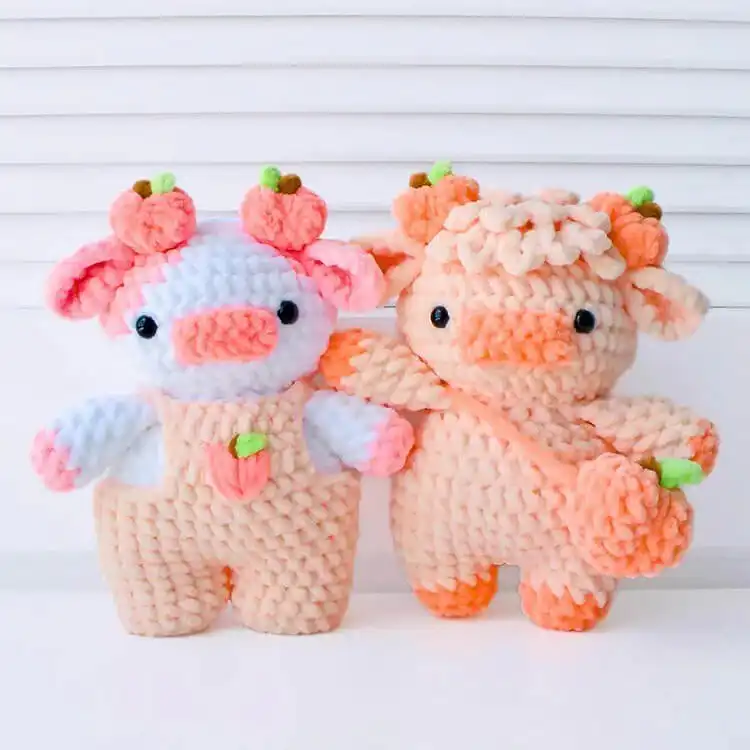 A group of adorable crochet fruit cows, each representing a different fruit like strawberry, blueberry, and orange, from the 10-in-1 Fruit Cows pattern.