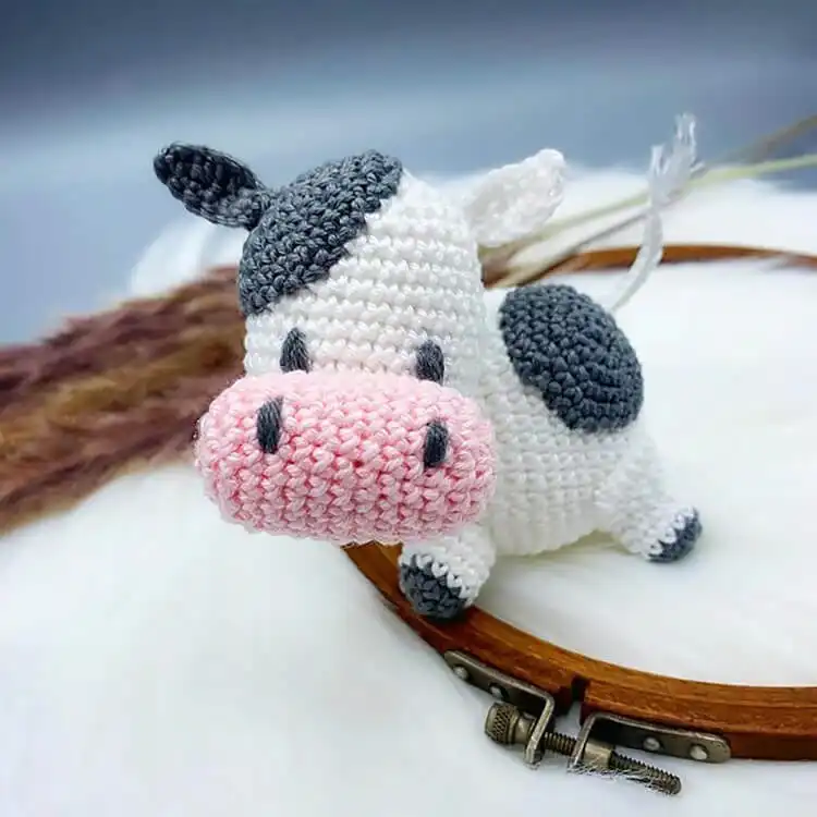 A charming crochet Harvest Moon Cow in autumnal colors, perfect for cozy decor, featuring earthy tones and a friendly expression.
