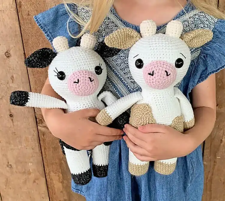 A simple yet charming black and white Amigurumi Cow crochet plushie, standing upright with a friendly face.