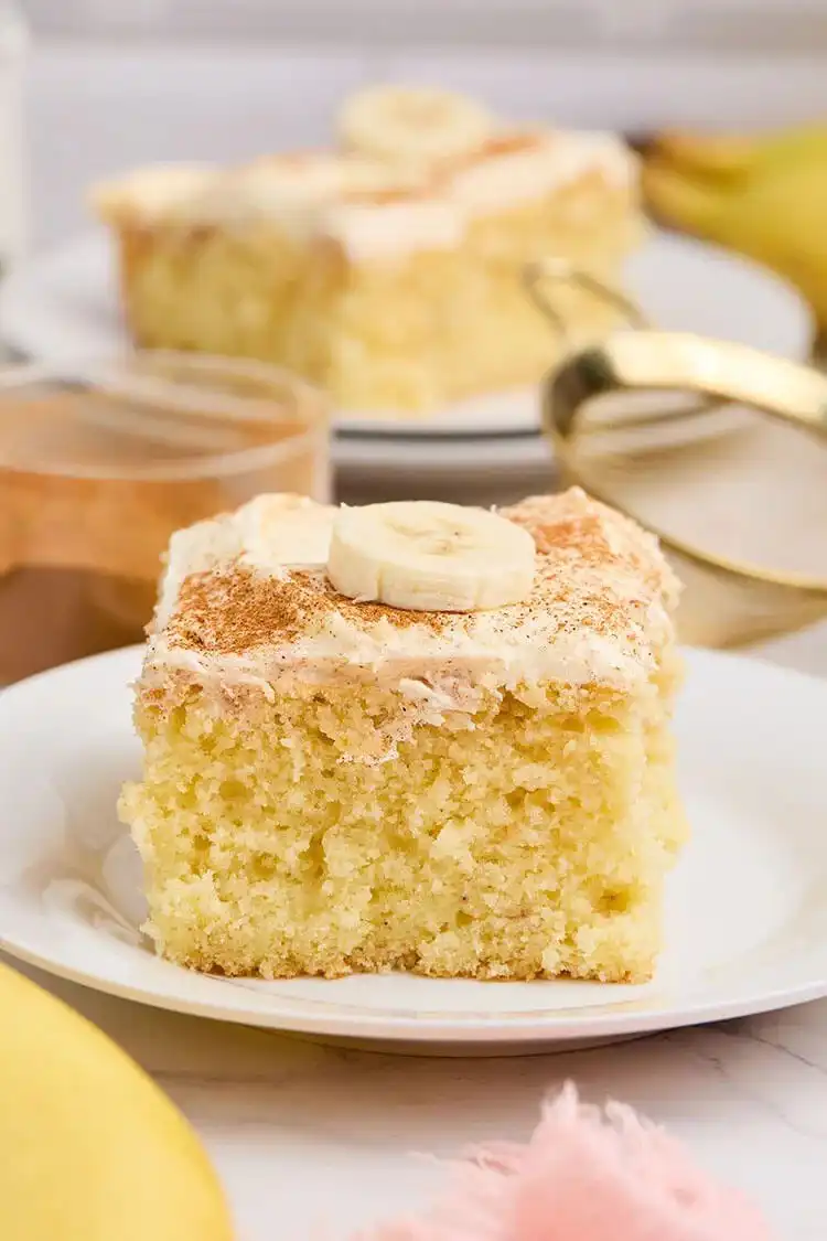 Slice of moist banana sheet cake with creamy frosting