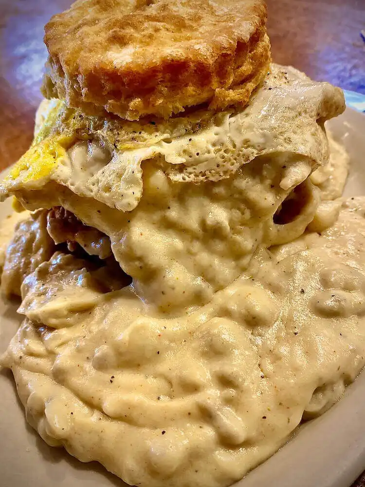 Fried squirrel with fluffy biscuits and creamy gravy on a plate, a traditional Southern breakfast