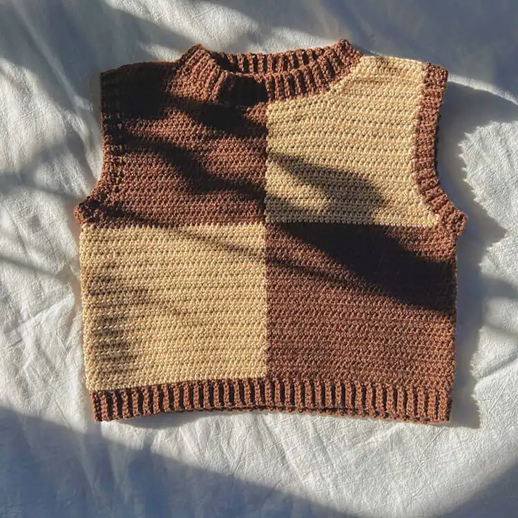 A stylish Checkerboard Sweater Vest in two contrasting colors, featuring a boxy, slightly oversized fit.