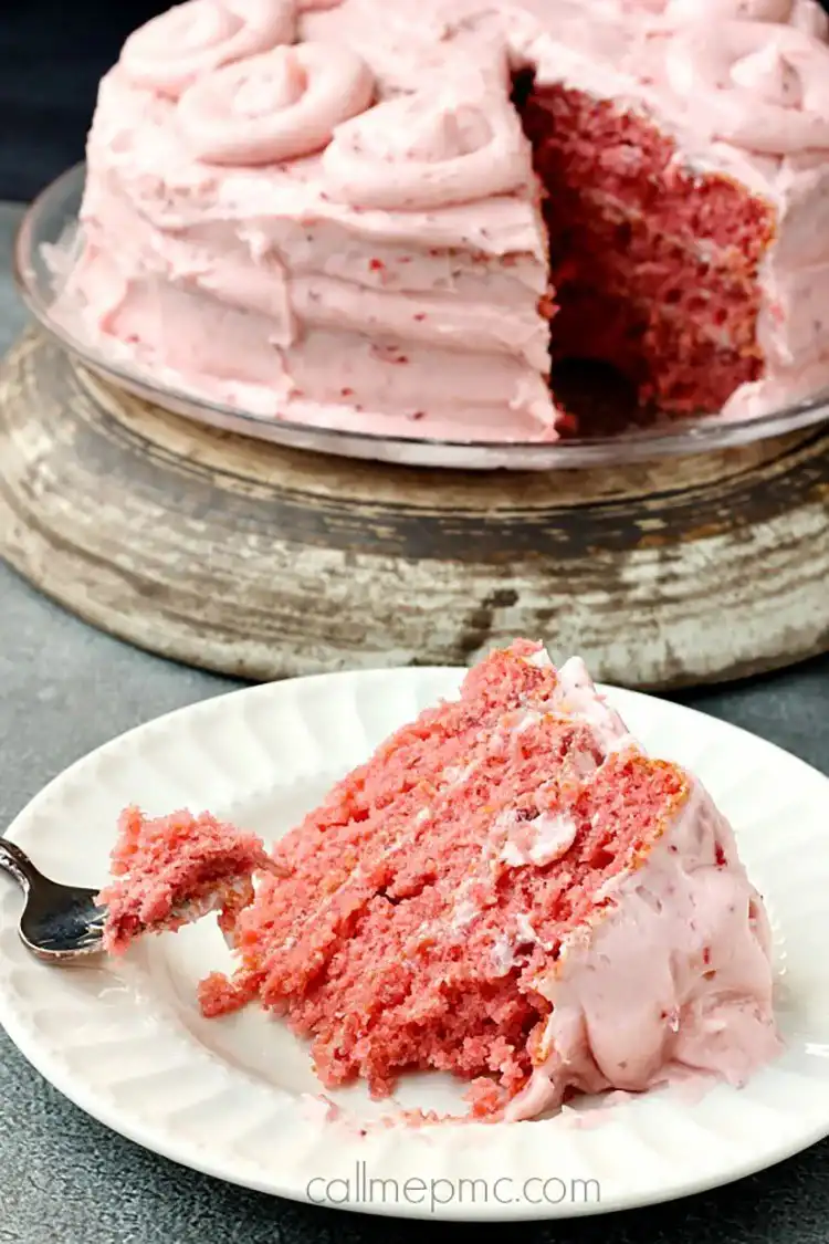 A vibrant strawberry cake with fresh strawberry frosting, looking moist and tender.