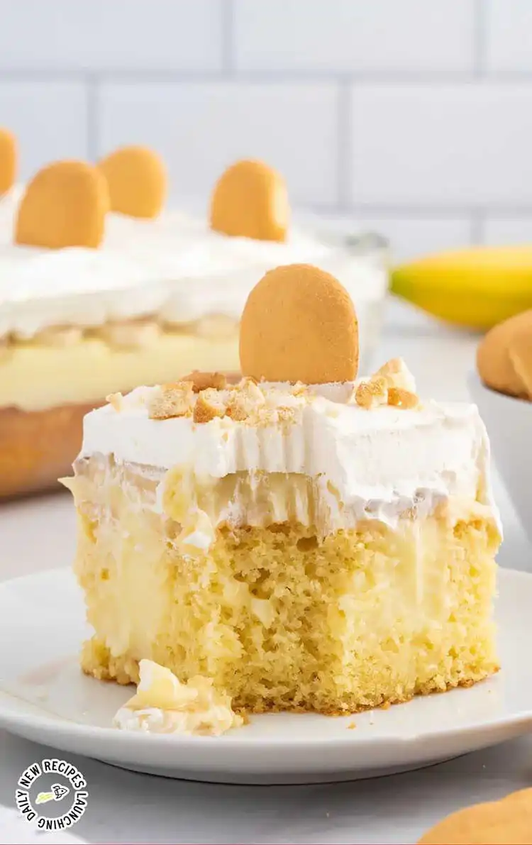A layered banana pudding cake with vanilla sponge, creamy pudding, and fresh banana slices.