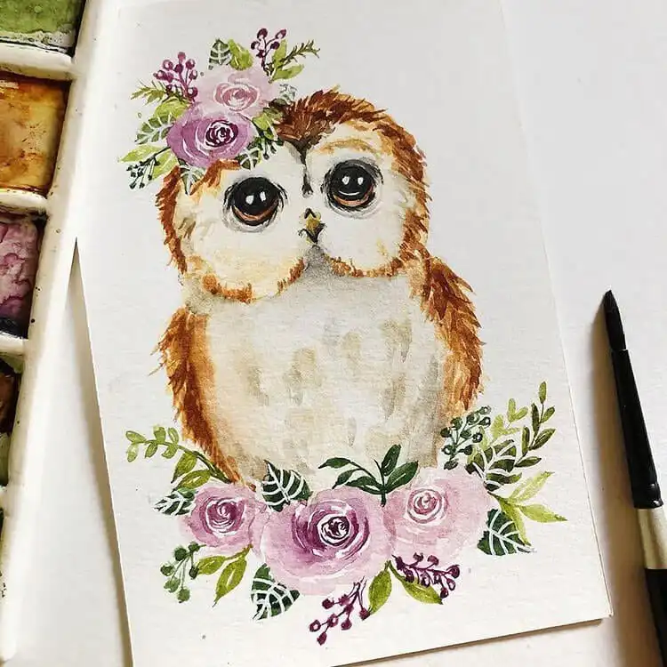 Charming watercolor owl painting adorned with colorful flowers, suitable for greeting card designs.
