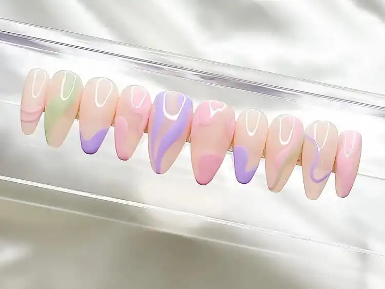 DIY press-on nails with intricate pastel designs, offering an easy way to achieve salon-quality manicures at home.